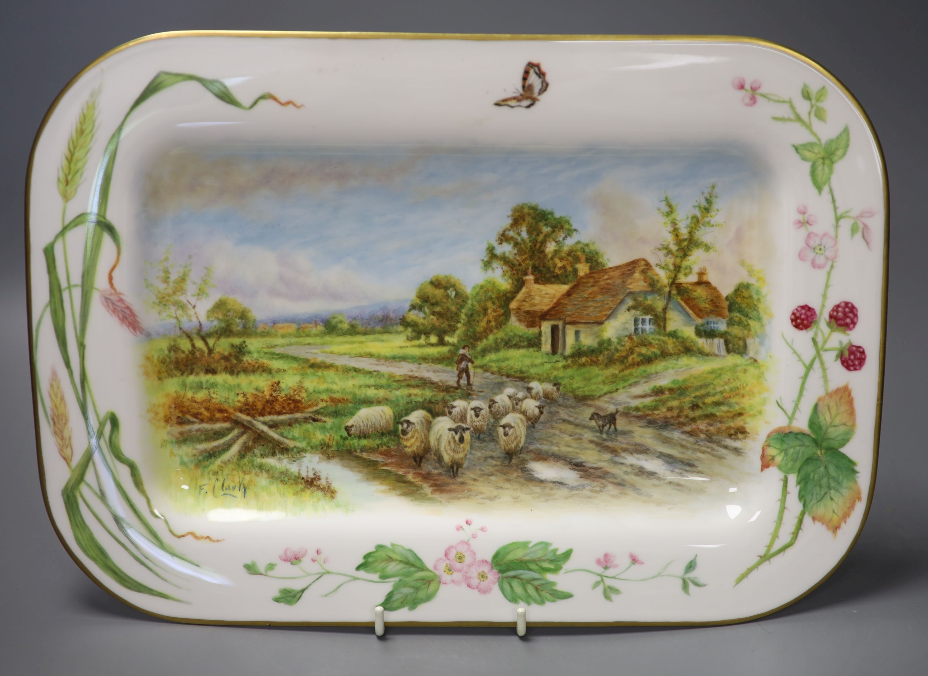 A rectangular dish with rounded corners painted with painted with sheep, a man and dog and a country house by Francis Clark, signed fro